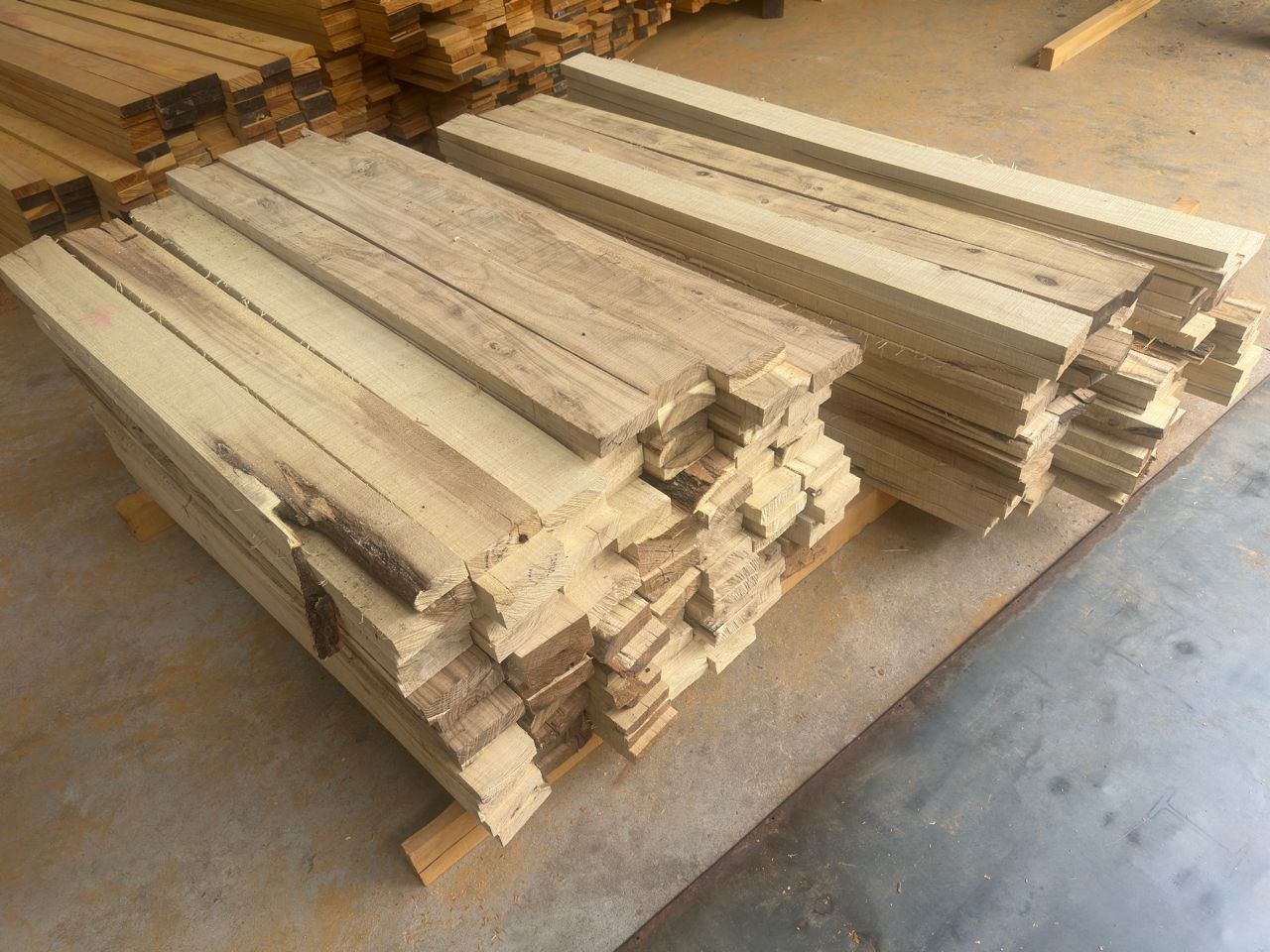 Freshly milled Robinia hardwood planks stacked in the Hon Playground factory, ready to build the customized pirate ship playground.